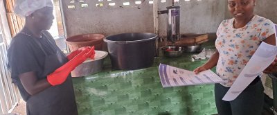 Açaí Boosters team member Lateefa (right) discusses hygiene and handling practices with a local açaí-pulp processor, Mrs. Margo, at her workplace in Albina.